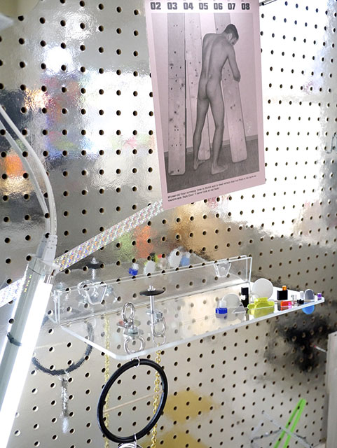 "Carpenter" (2014). Holographic and glitter tape, mirror ball, Acrylic shelf & acrylic and plastic pieces, metal hardware, aluminum tubing, Styrofoam, Butt calendar image, Acryla gouache on paper, chain, metal hardware, rubber, rhinestones, on custom Mylar pegboard // 59" x 50" x 8" Carpenter_detail2_web